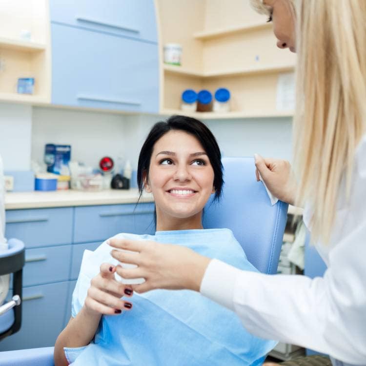 Pacientka se usmívá a komunikuje s zubařkou v ordinaci.