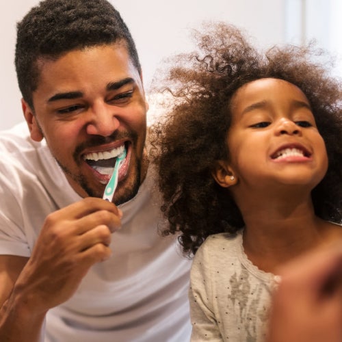 Otec a dcera si společně čistí zuby